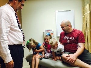Dr. Cripe giving the kids a ride up and down on the exam table. He even lifted them up there himself.